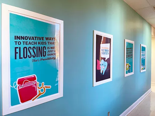 Educational dental posters line Advantage Dental+ hallways.