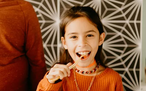 Young girl brushing teeth.