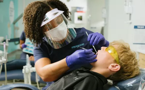 A dental provider working on a pediatric patient.