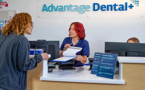 A patient speaking to an employee about how to schedule an appointment at Advantage Dental+.
